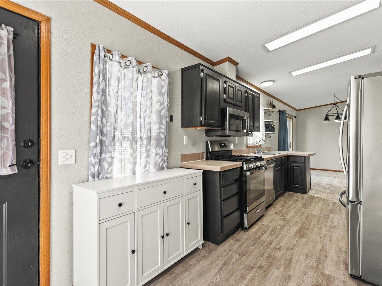 8686 Dutch Elm Court Roscoe, IL 61073 - Photo 14 of 33 a kitchen with stainless steel appliances a sink cabinets and wooden floor