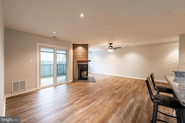 a view of an empty room with a window and wooden floor