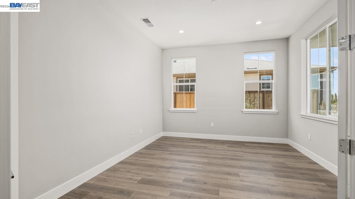 756 Conrad Street Manteca, CA 95336 - Photo 22 of 41 a view of an empty room with wooden floor and a window