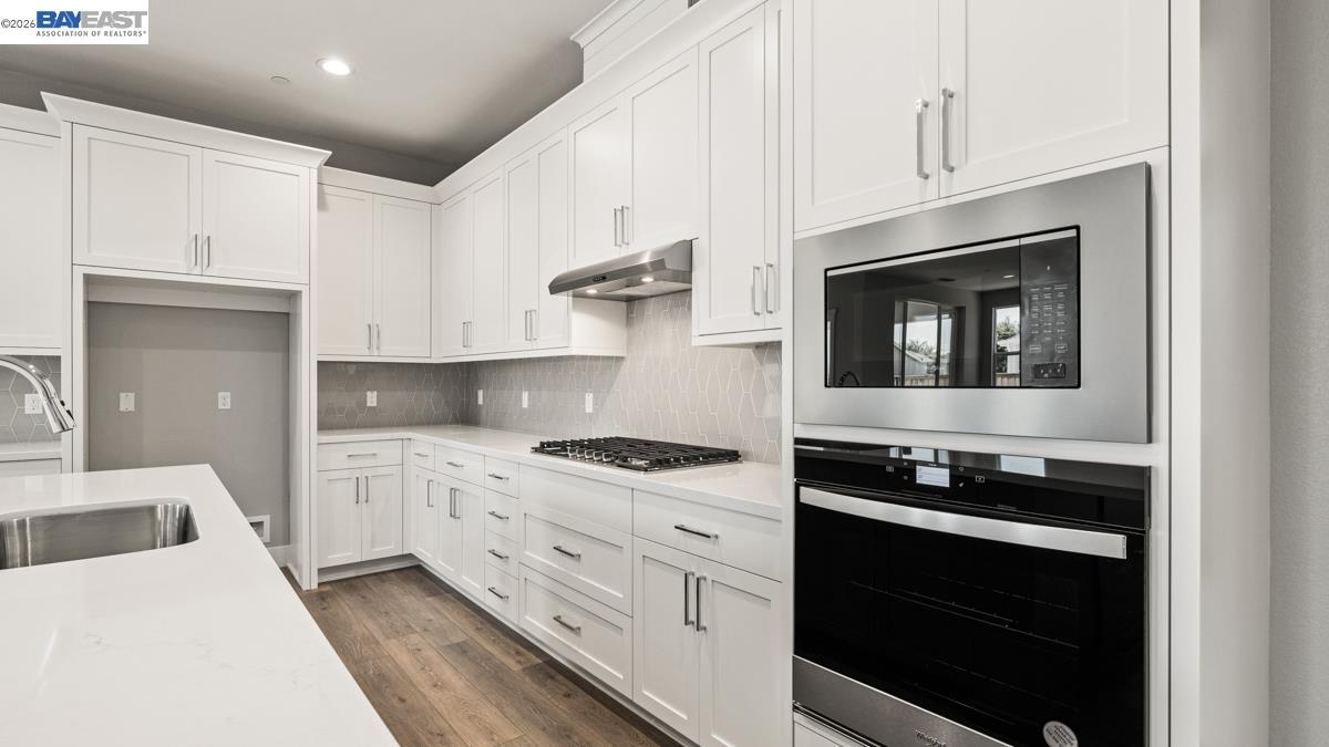 756 Conrad Street Manteca, CA 95336 - Photo 6 of 41 a kitchen with stainless steel appliances white cabinets and stove