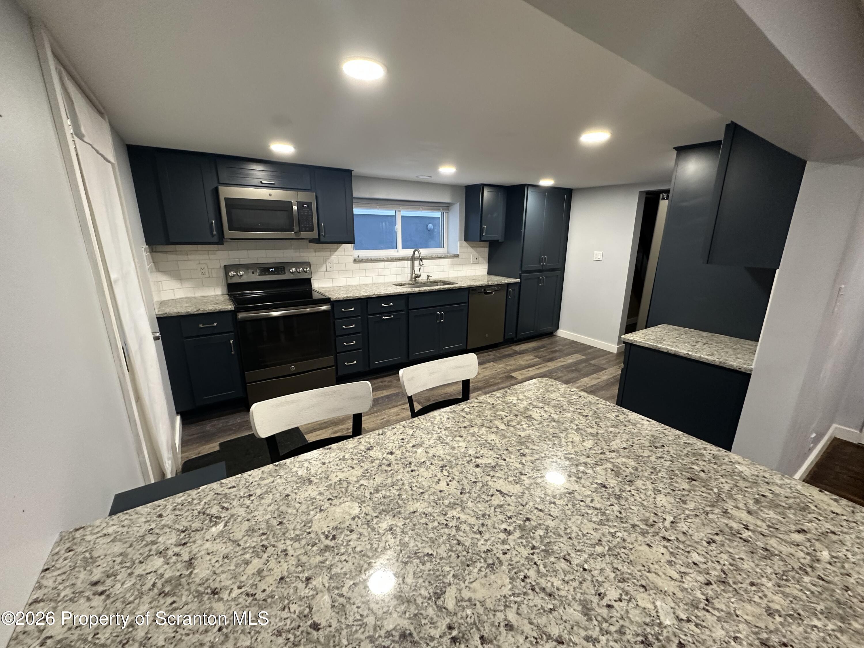 611 Chestnut Street Dunmore, PA 18512 - Photo 3 of 27 a large kitchen with a sink and refrigerator