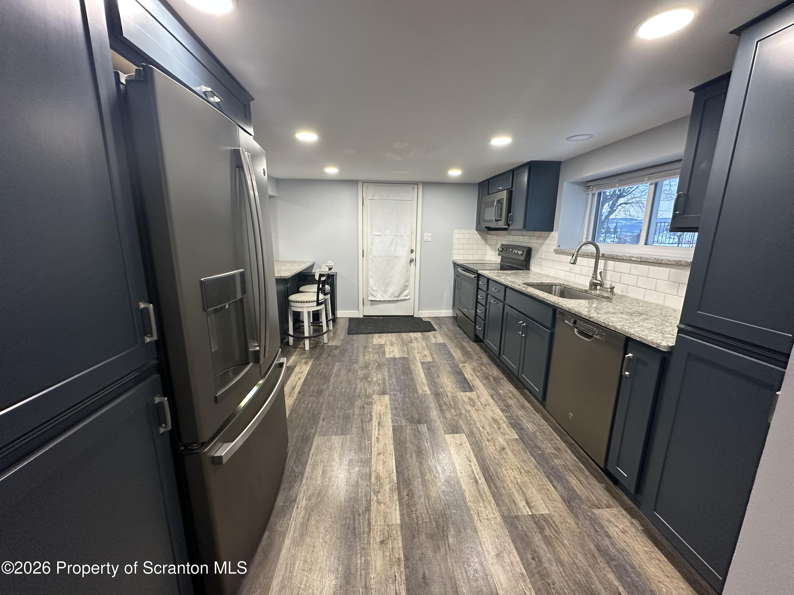 611 Chestnut Street Dunmore, PA 18512 - Photo 4 of 27 a large kitchen with a sink and refrigerator
