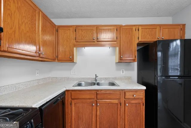 a kitchen with stainless steel appliances granite countertop a refrigerator and a sink