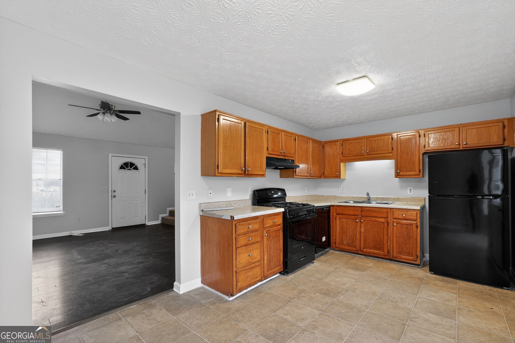 5207 Oaktree Court Lithonia, GA 30038 - Photo 12 of 39 a kitchen with granite countertop stainless steel appliances a refrigerator cabinets and wooden floor