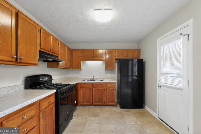 a kitchen with stainless steel appliances granite countertop a refrigerator a stove a sink and a microwave