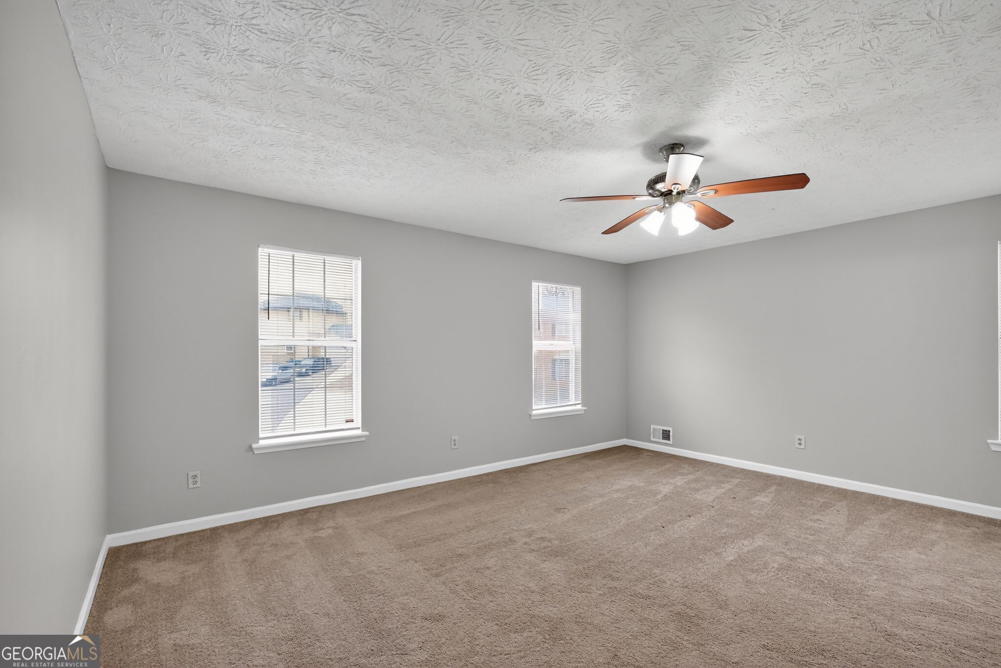 5207 Oaktree Court Lithonia, GA 30038 - Photo 25 of 39 an empty room with windows and ceiling fan