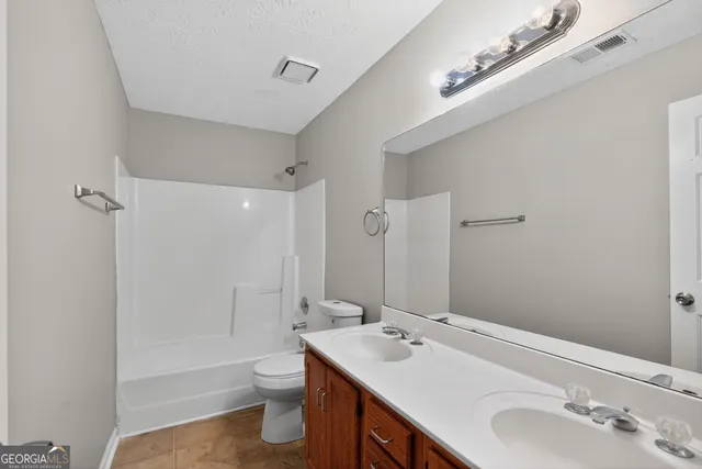 a bathroom with a double vanity sink toilet and shower