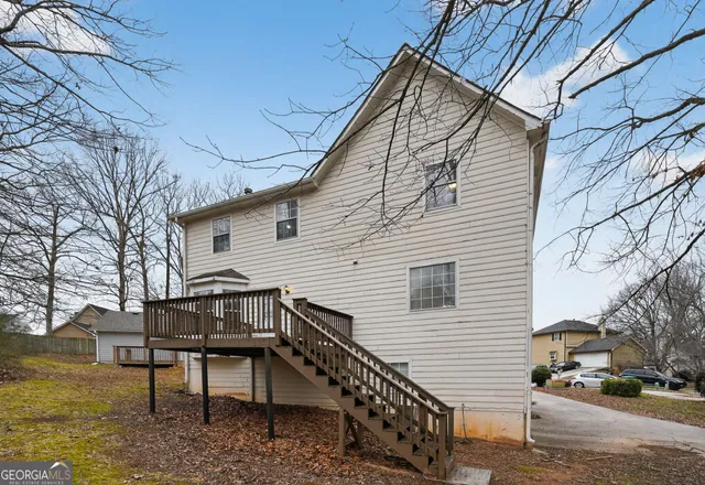a view of a house with a bench next to a yard