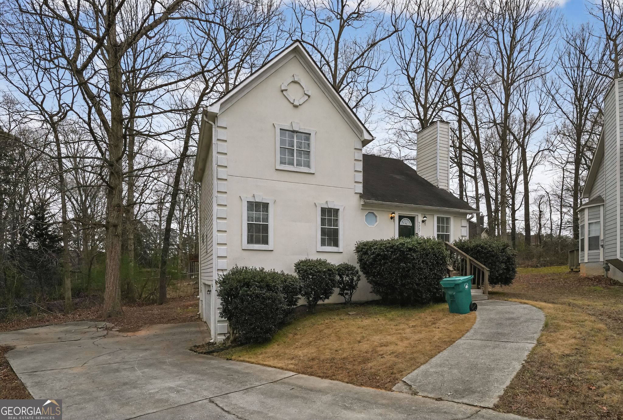 5207 Oaktree Court Lithonia, GA 30038 - Photo 6 of 39 a view of a house with a yard covered with plants and large trees