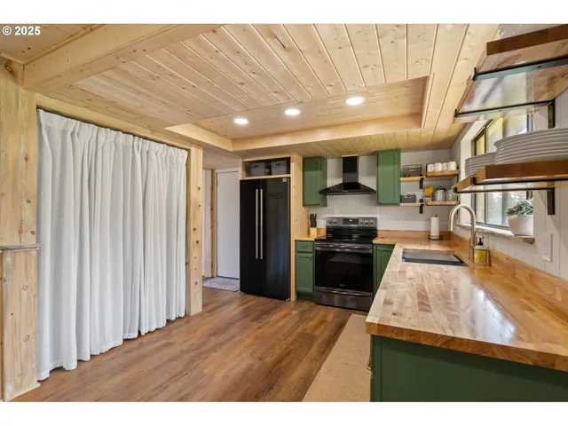 a kitchen with kitchen island a counter top space a sink and a stove