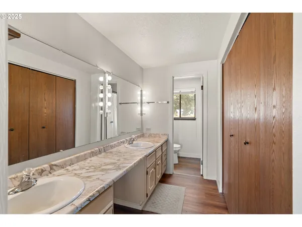 a bathroom with a sink double vanity granite tub shower and a mirror