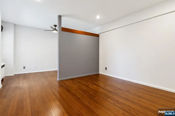 a view of an empty room with wooden floor