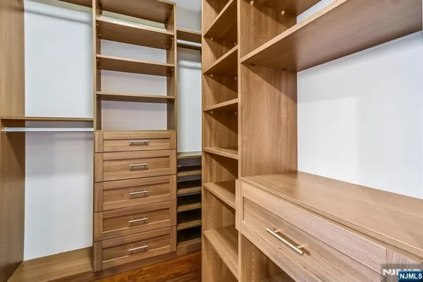 a view of walk in closet with empty racks