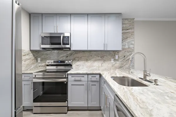 a kitchen with white cabinets appliances and sink