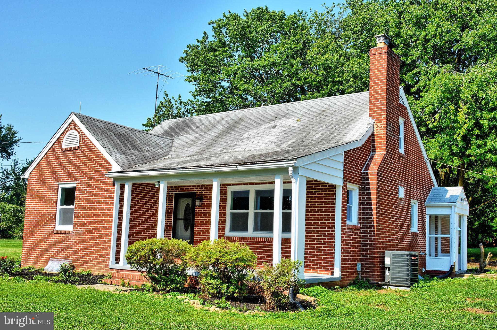12408 Regwood Road Hydes, MD 21082 - Photo 2 of 17 a view of a house with brick walls and a yard with plants