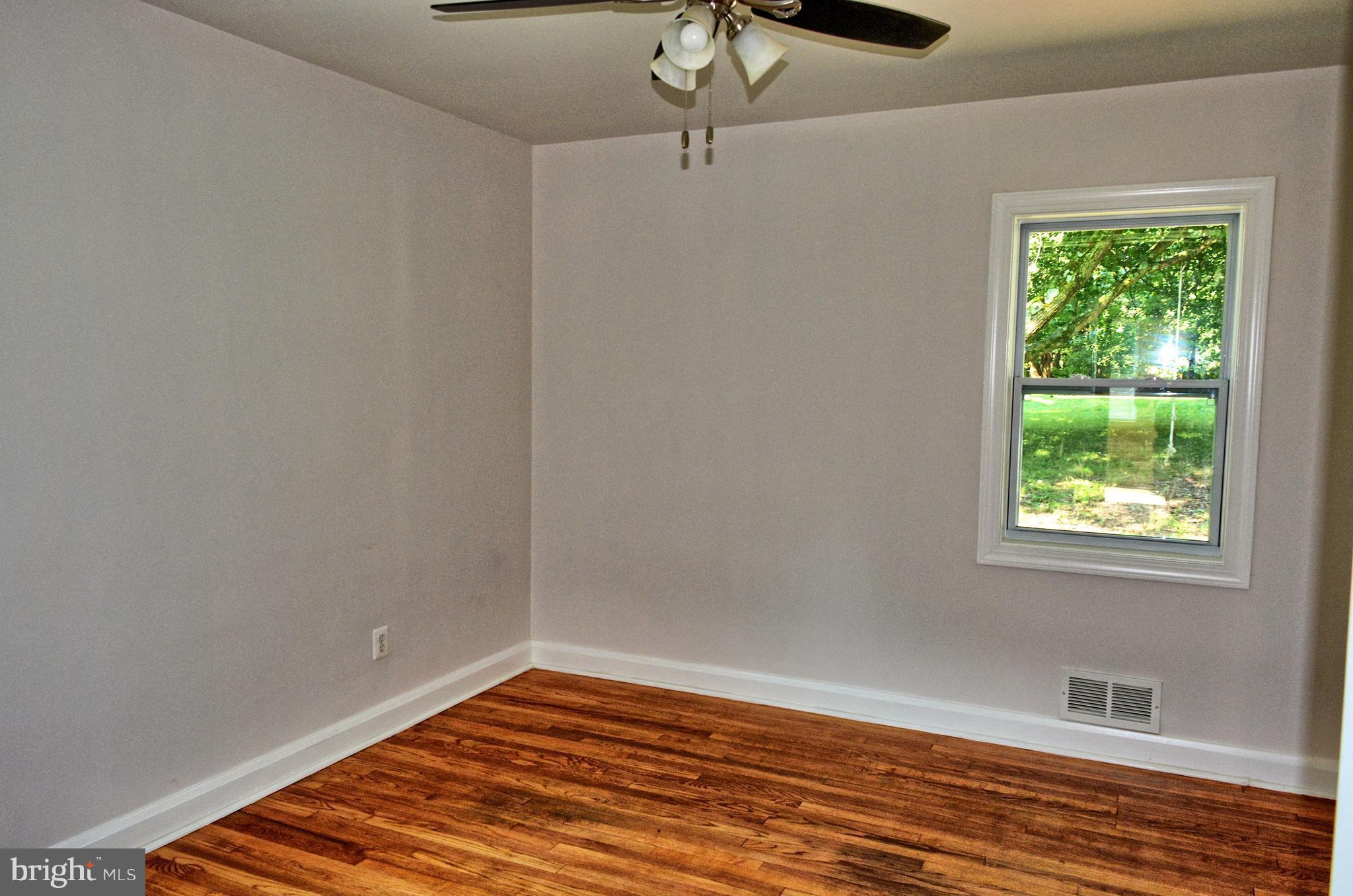 12408 Regwood Road Hydes, MD 21082 - Photo 9 of 17 a view of an empty room with wooden floor and a window