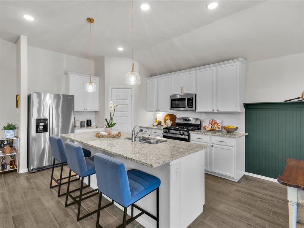 13141 Yellowstone Way Providence Village, TX 76227 - Photo 12 of 40 a kitchen with stainless steel appliances granite countertop a refrigerator a stove top oven a sink dishwasher and wooden cabinets
