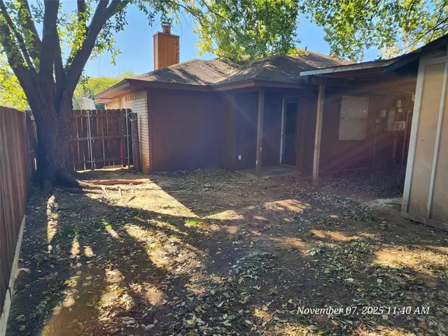 a view of a yard with wooden fence
