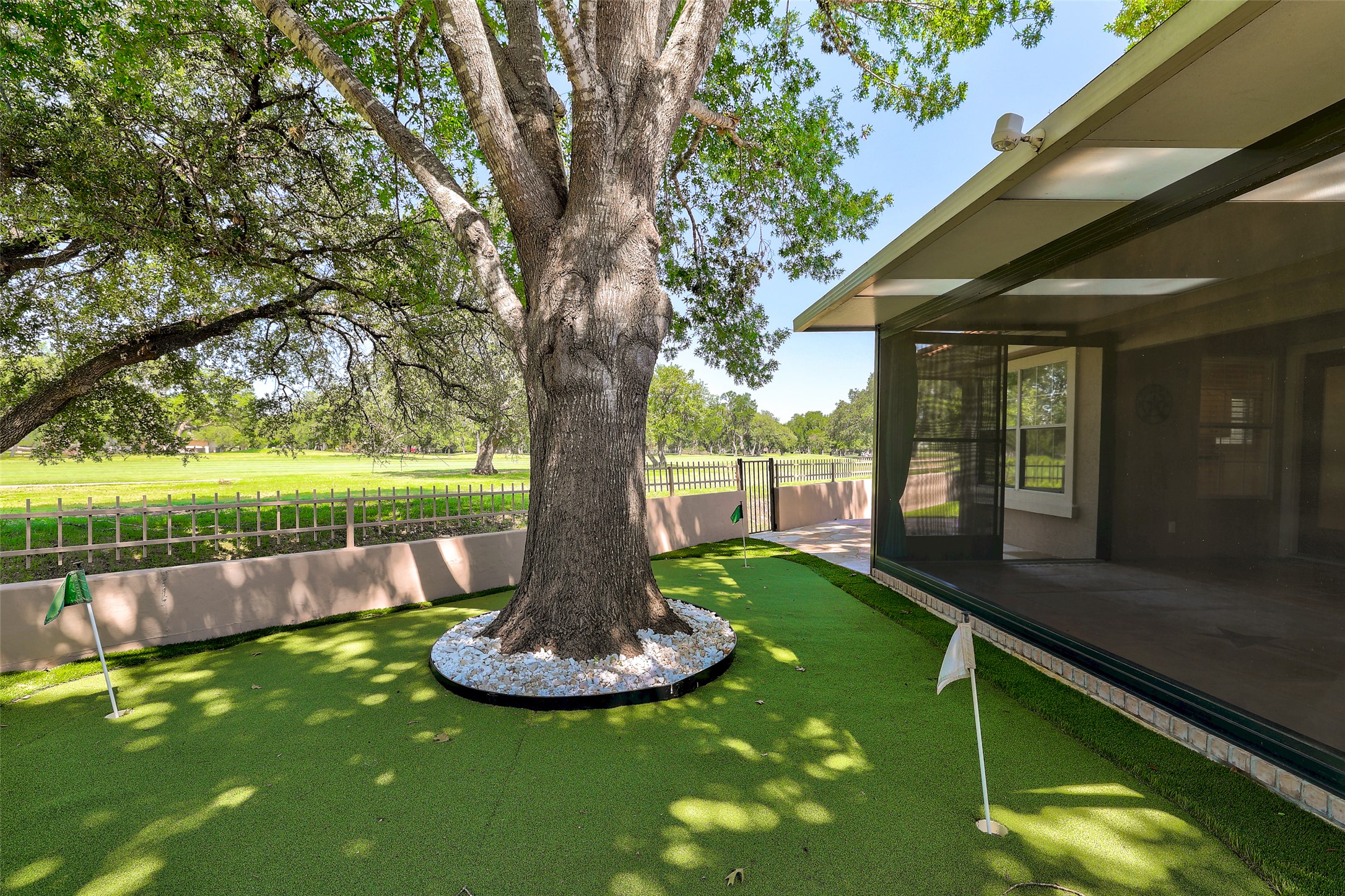 30107 Hamlet Circle Georgetown, TX 78628 - Photo 29 of 40 A private putting green extends from the covered patio, framed by mature trees and views of the golf course.