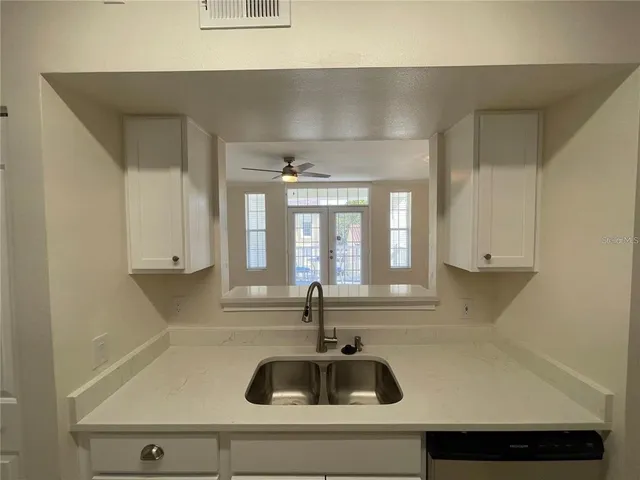 a kitchen with a sink and white cabinets