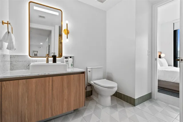 a bathroom with a granite countertop sink and a mirror