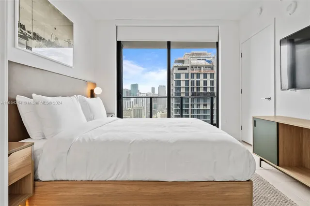 a large bed sitting in a bedroom next to a window
