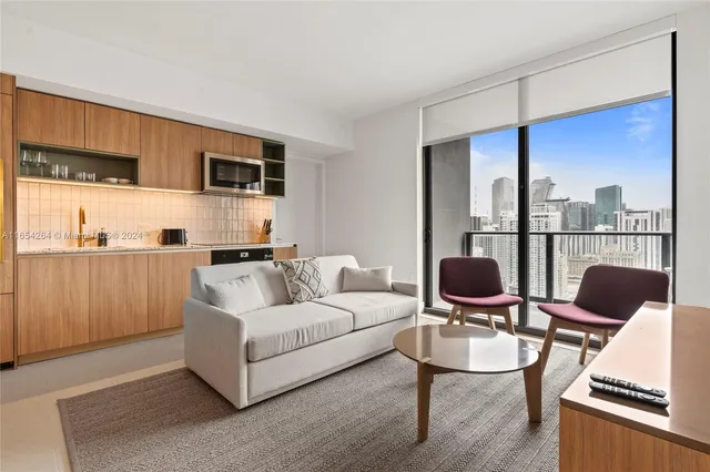 a living room with furniture and a view of kitchen