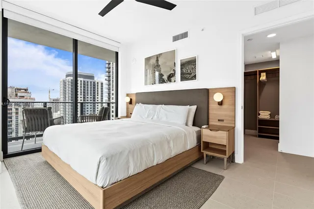 a large bed sitting in a bedroom next to a window