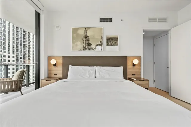 a bedroom with a bed and painting on the wall