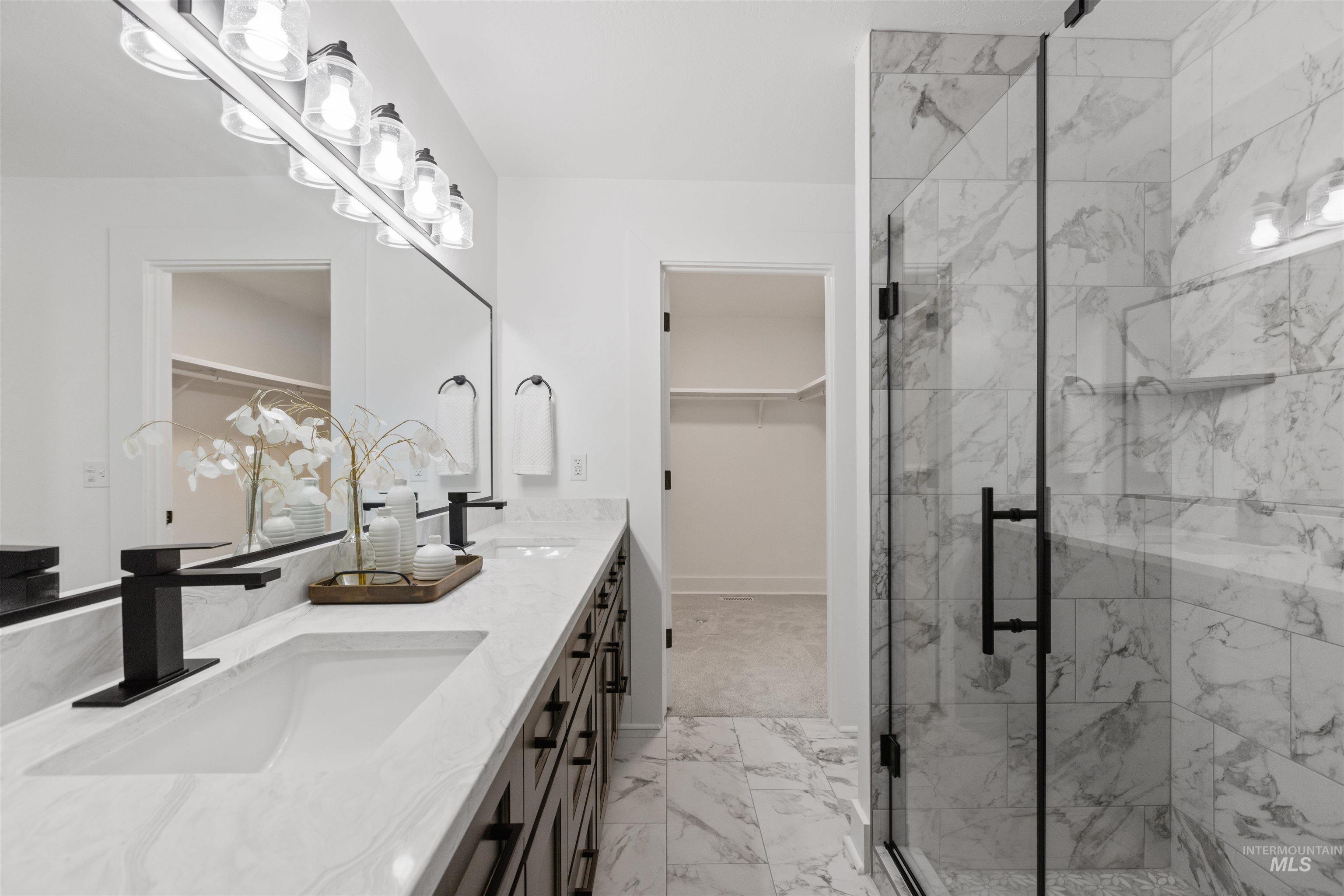 29862 Emmett Road Caldwell, ID 83607 - Photo 22 of 44 Full bath featuring double vanity, a marble finish shower, a walk in closet, and light marble finish floors