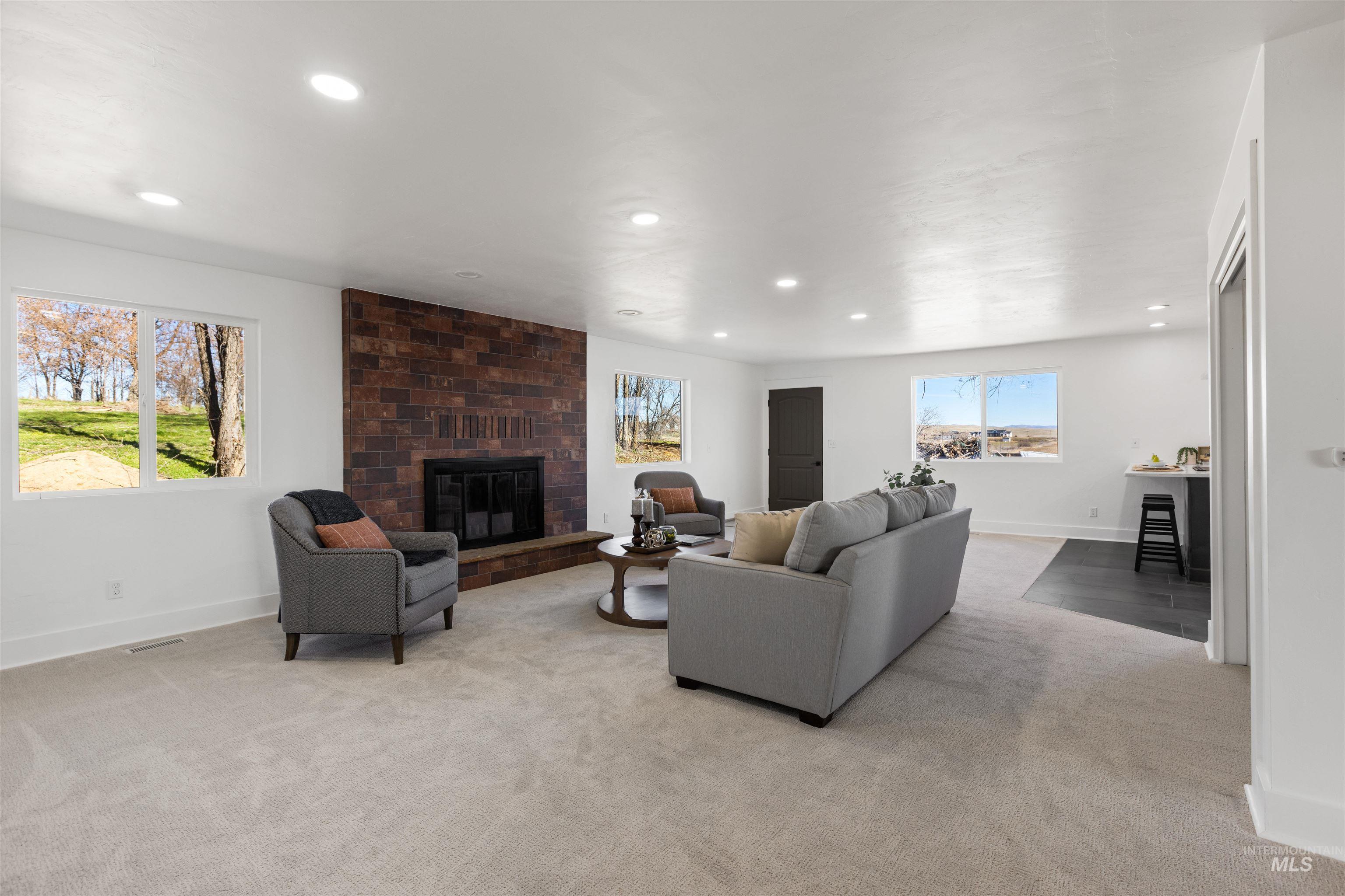 29862 Emmett Road Caldwell, ID 83607 - Photo 24 of 44 Living area featuring a fireplace, light colored carpet, and recessed lighting
