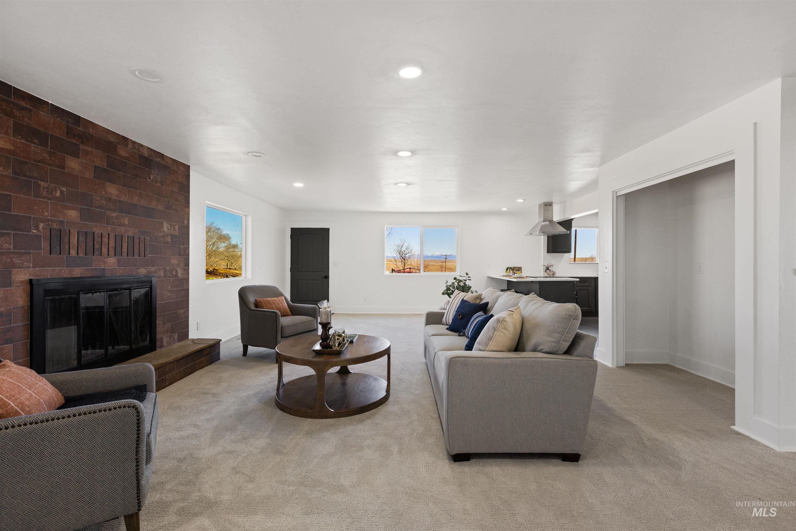 29862 Emmett Road Caldwell, ID 83607 - Photo 25 of 44 Living room featuring light colored carpet, a brick fireplace, and recessed lighting