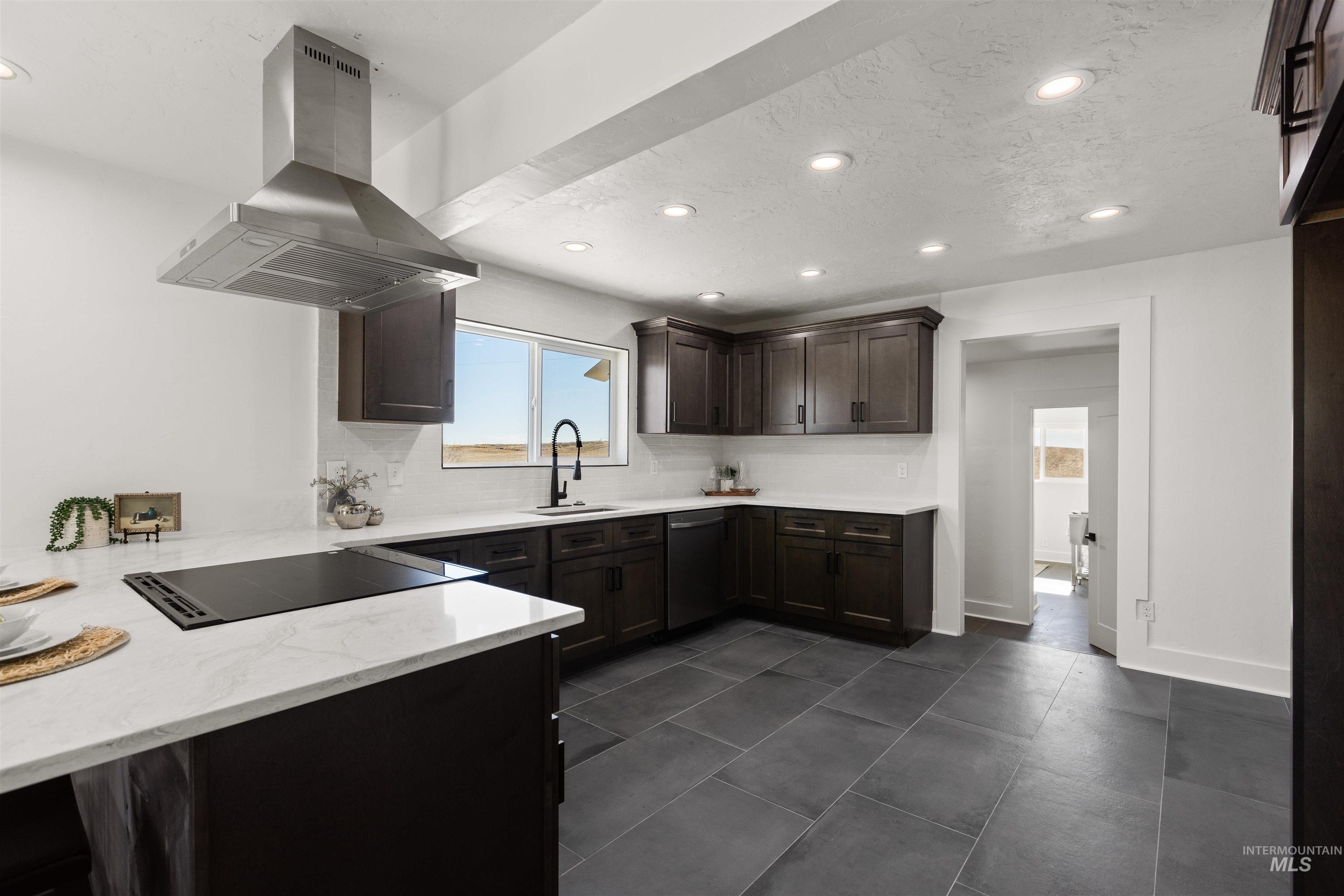 29862 Emmett Road Caldwell, ID 83607 - Photo 33 of 44 Kitchen featuring island exhaust hood, dark wood finish cabinetry, light stone countertops, recessed lighting, and stainless steel dishwasher