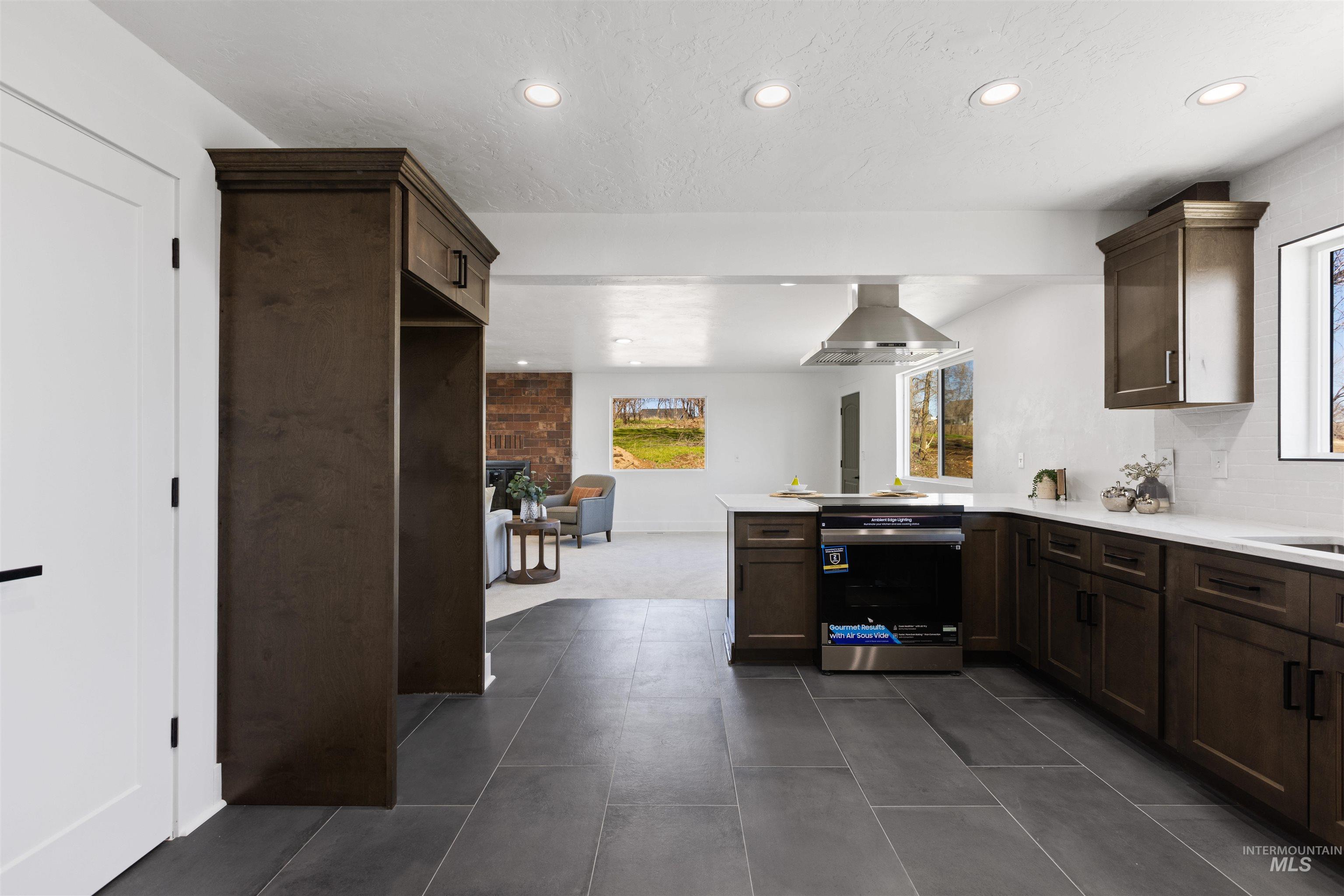 29862 Emmett Road Caldwell, ID 83607 - Photo 36 of 44 Kitchen featuring a peninsula, dark wood finish cabinets, stainless steel range oven, range hood, and recessed lighting