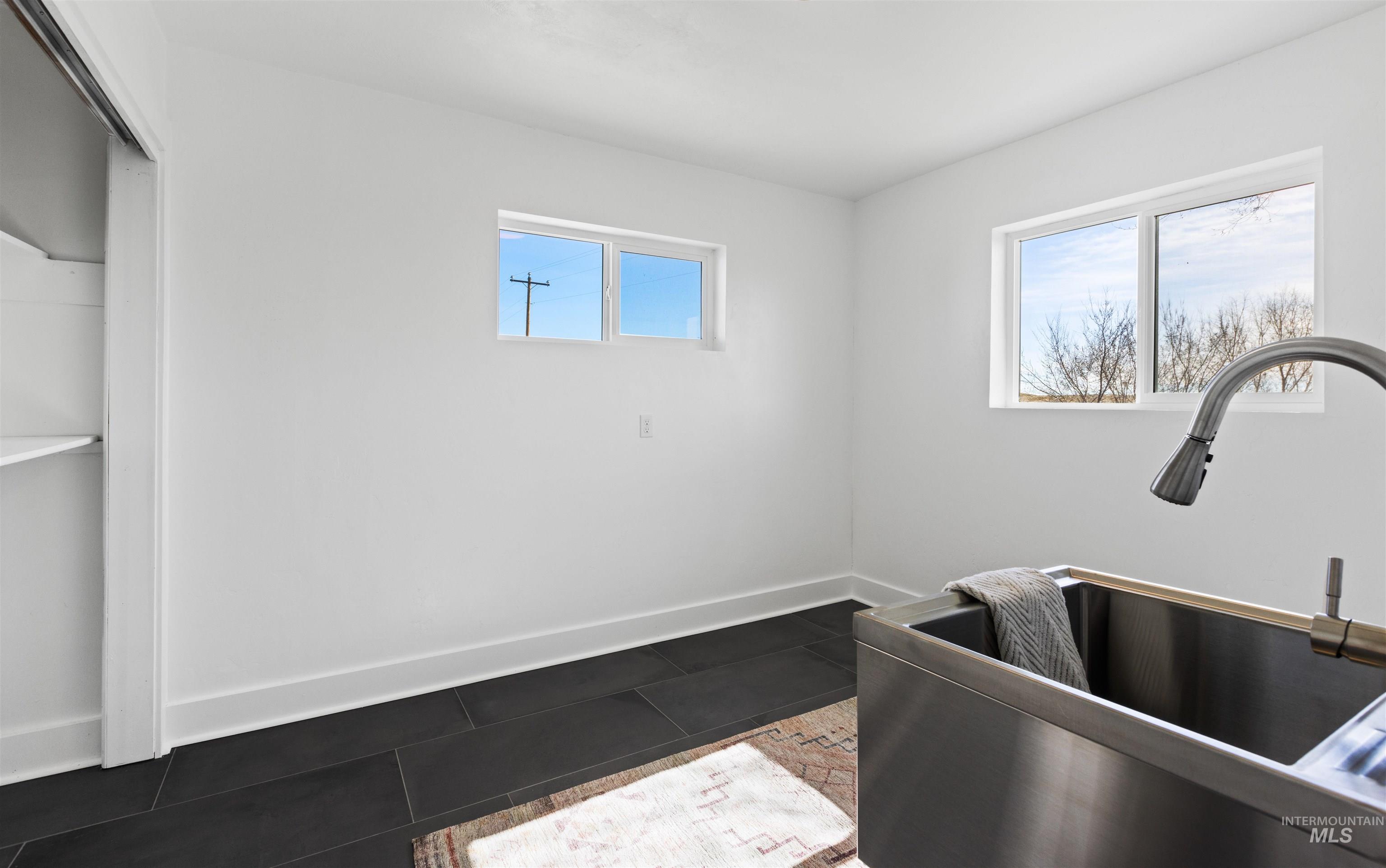 29862 Emmett Road Caldwell, ID 83607 - Photo 38 of 44 Laundry area featuring a sink and dark tile patterned flooring