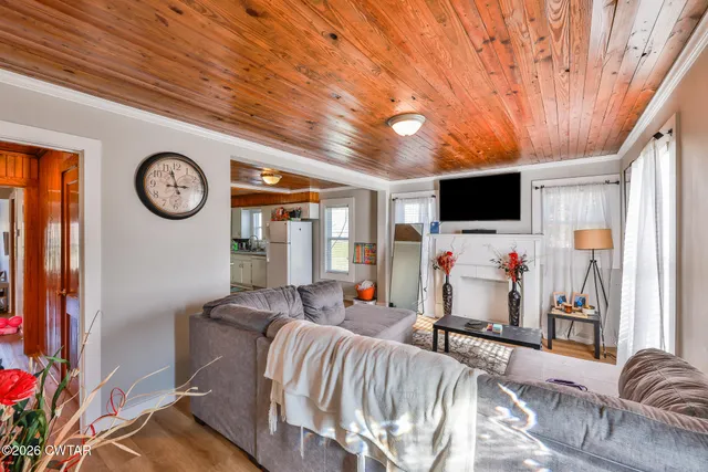 a living room with furniture a flat screen tv and a wall clock