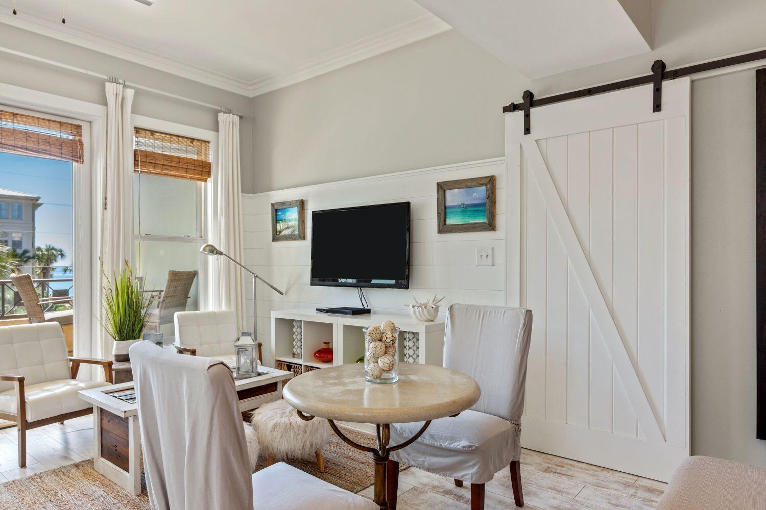 95 Laura Hamilton Boulevard, Unit 209 Santa Rosa Beach, FL 32459 - Photo 14 of 37 a living room with furniture a flat screen tv and a wooden floor