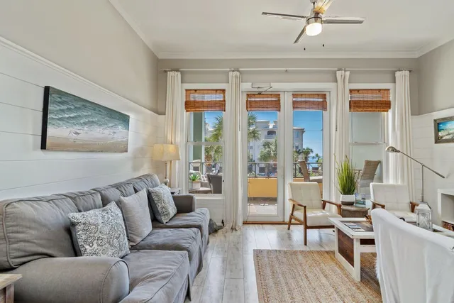 a living room with furniture a large window and wooden floor