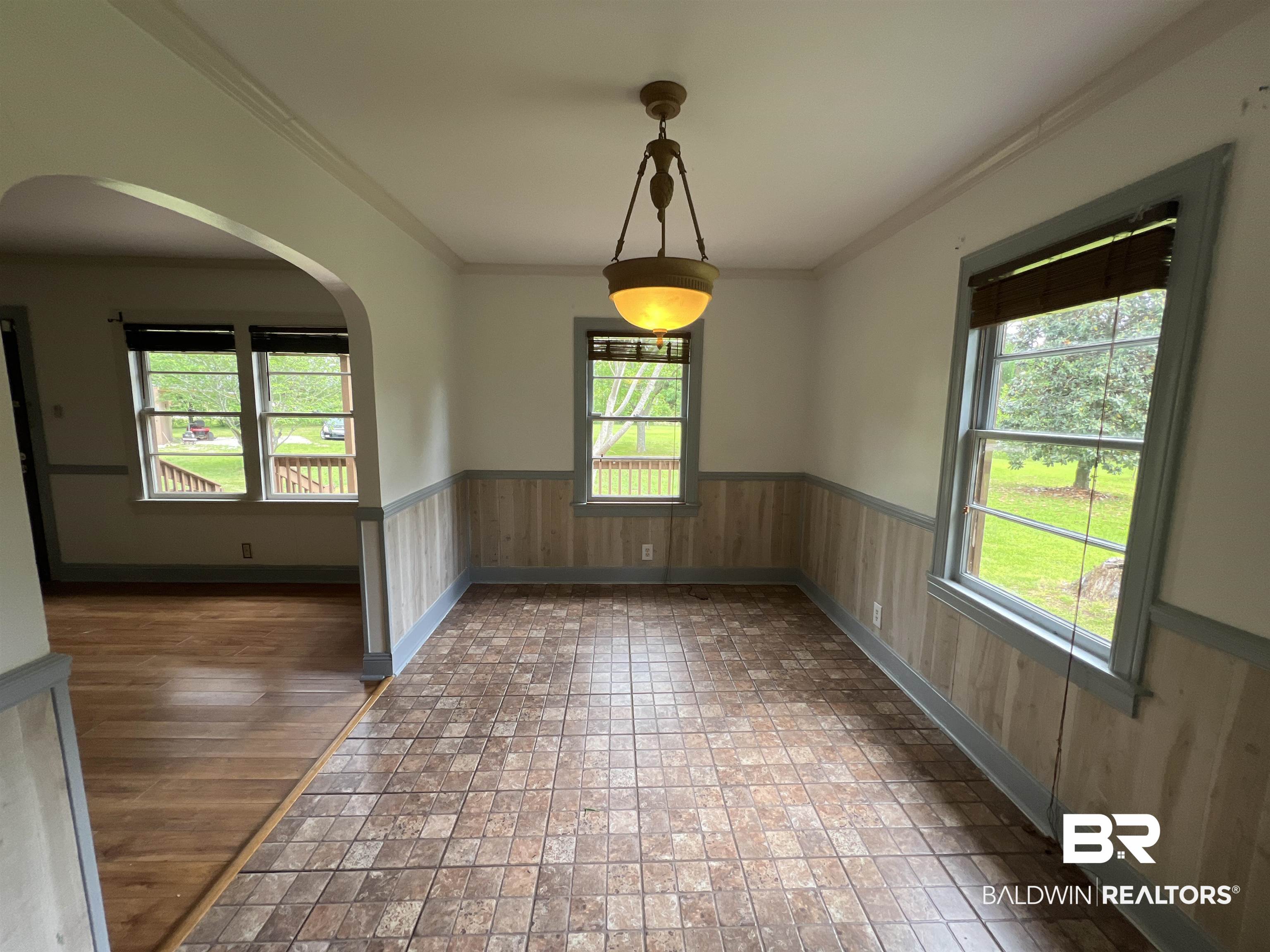 13301 A Hugh Fort Road Grand Bay, AL 36541 - Photo 7 of 34 Spare room with healthy amount of natural light, arched walkways, a wainscoted wall, crown molding, and baseboards