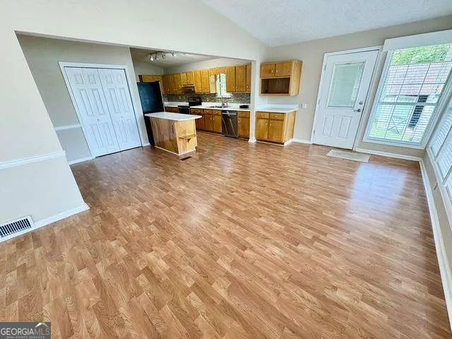 a view of a living room with furniture and wooden floor