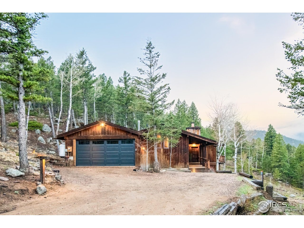 279 Forrest Lane Boulder, CO 80302 - Photo 2 of 36 a backyard of a house with table and chairs under an umbrella