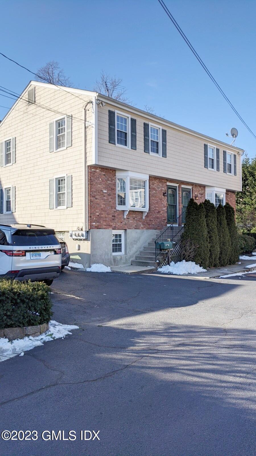 a front view of a house with garden and parking