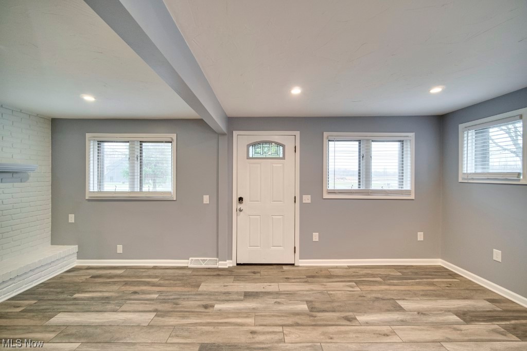 7060 Lear Nagle Road North Ridgeville, OH 44039 - Photo 20 of 29 Entrance foyer with light hardwood / wood-style flooring, brick wall, and a healthy amount of sunlight