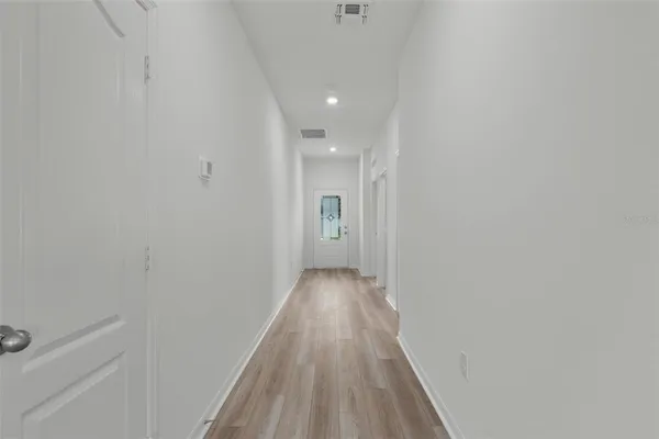 a view of a hallway with wooden floor