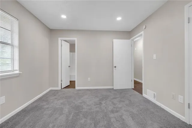 an empty room with windows and closet