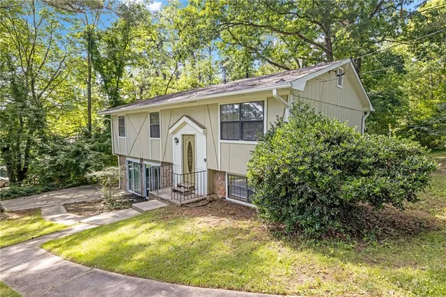 a view of house with backyard and sitting area