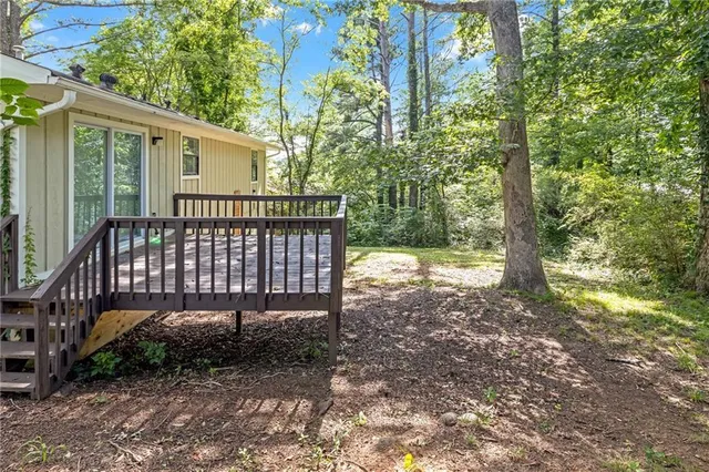 a view of a yard with a chair and table in the patio