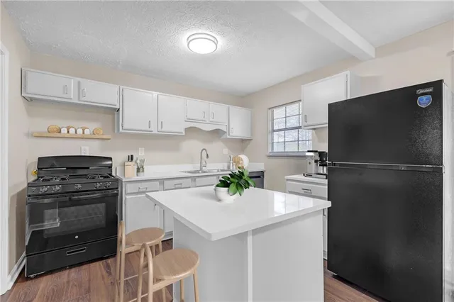 a kitchen with a sink a refrigerator and a stove top oven