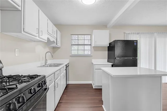 a kitchen with stainless steel appliances a sink stove and cabinets