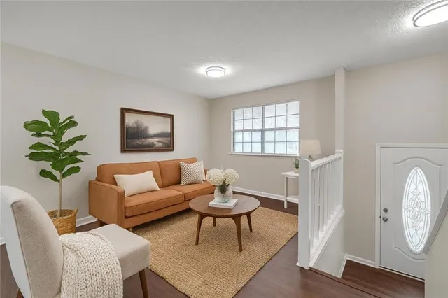 a living room with furniture a window and a potted plant